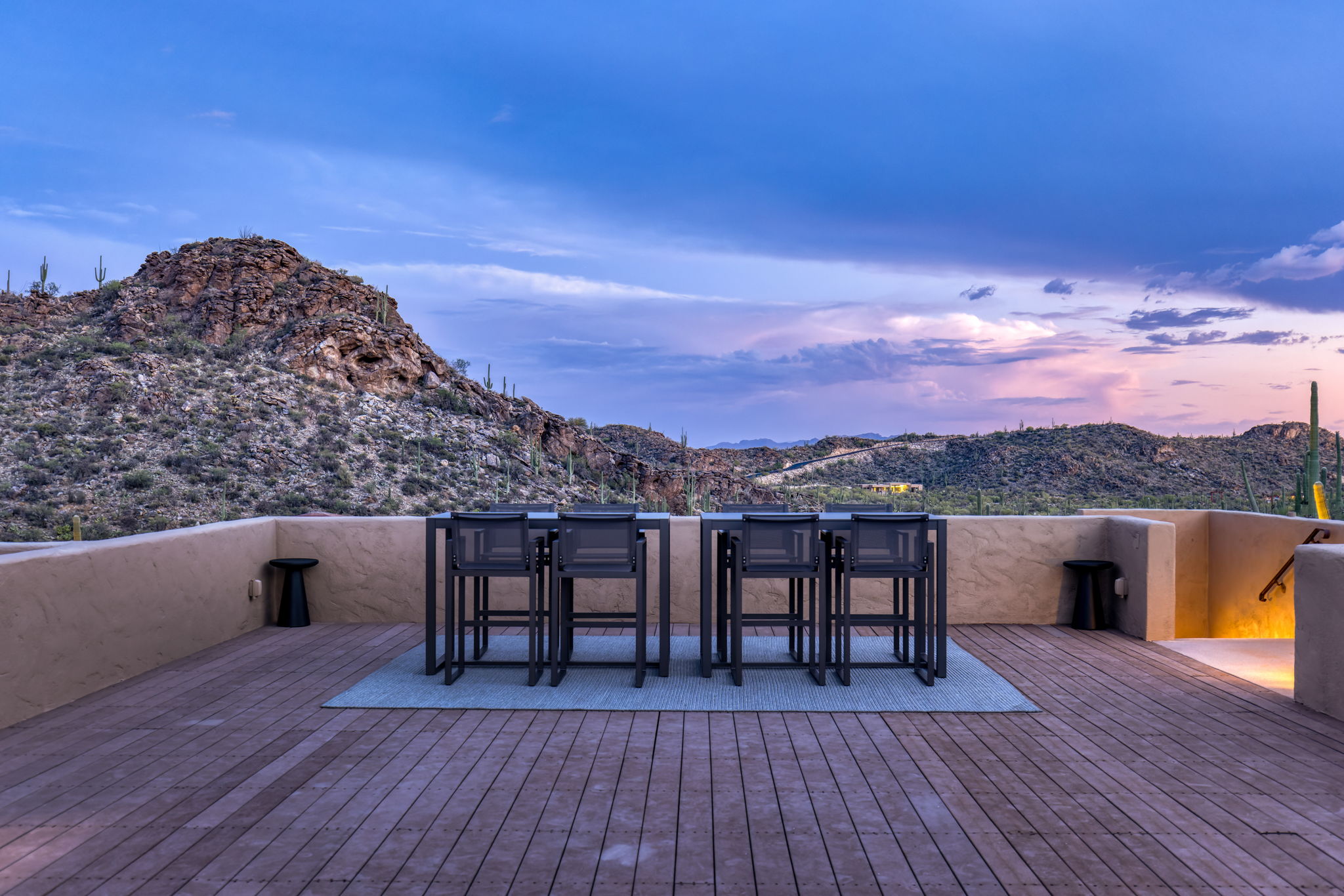 Bar seating on the rooftop deck facing the ridge at dusk