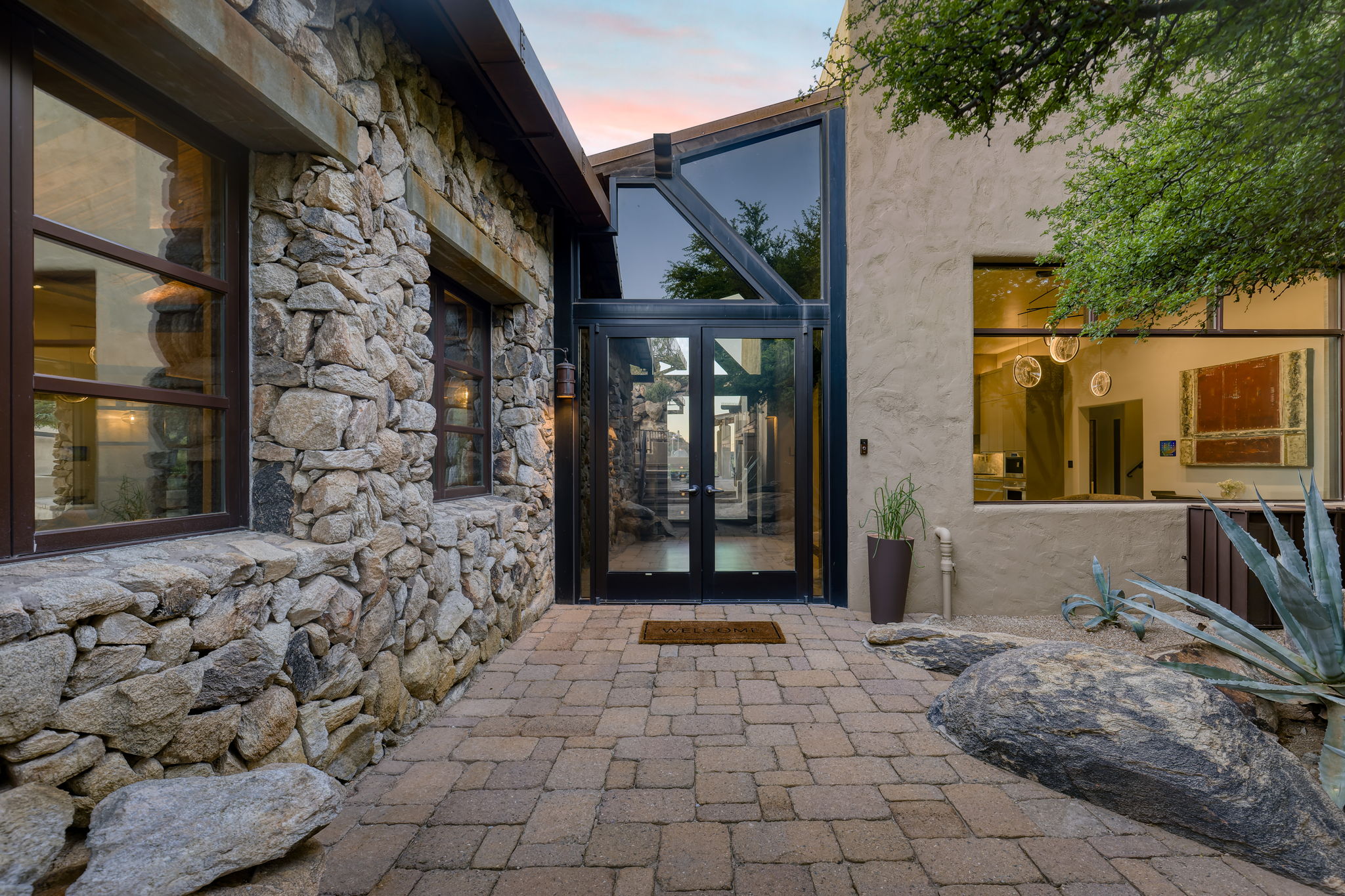 Stone and glass entry doors at dusk