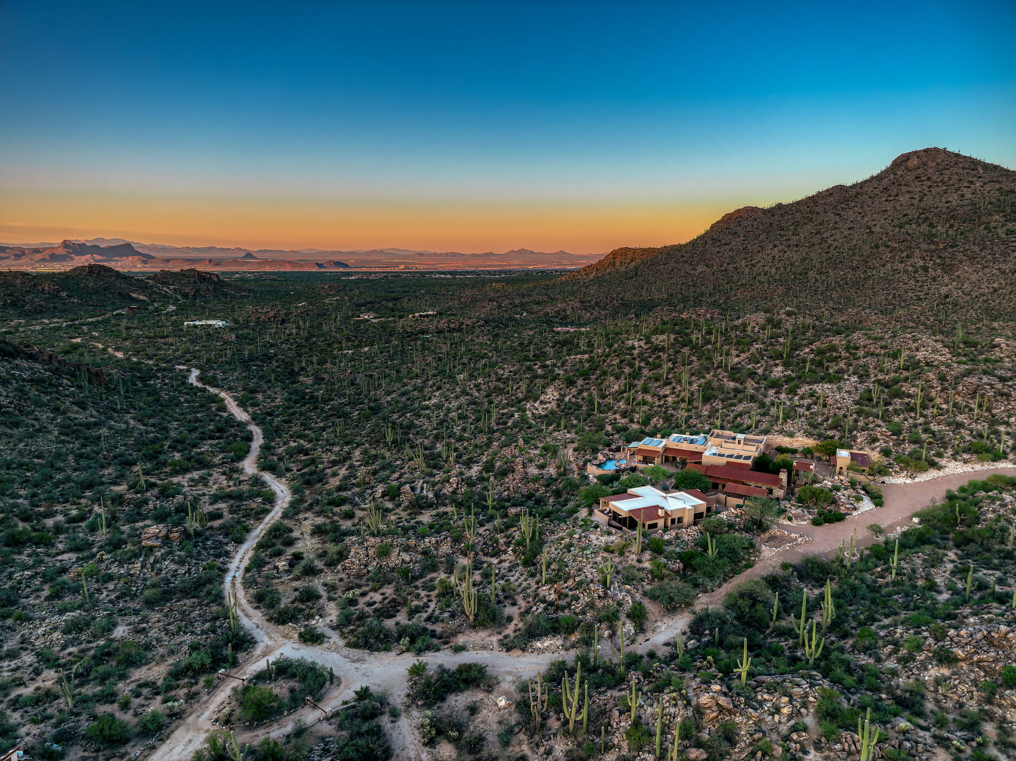 Aerial at dusk, the compound alone in the desert valley