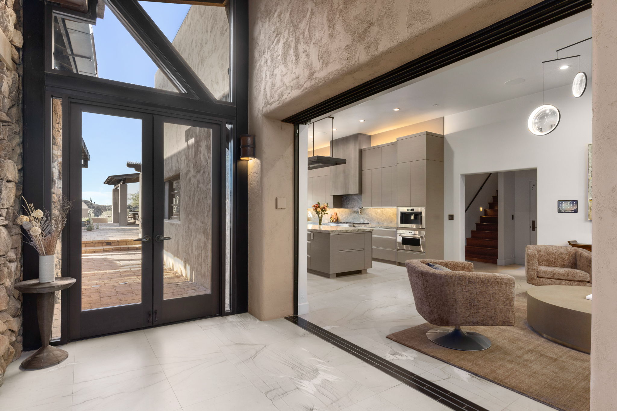 Double-height stone entry with marble floors