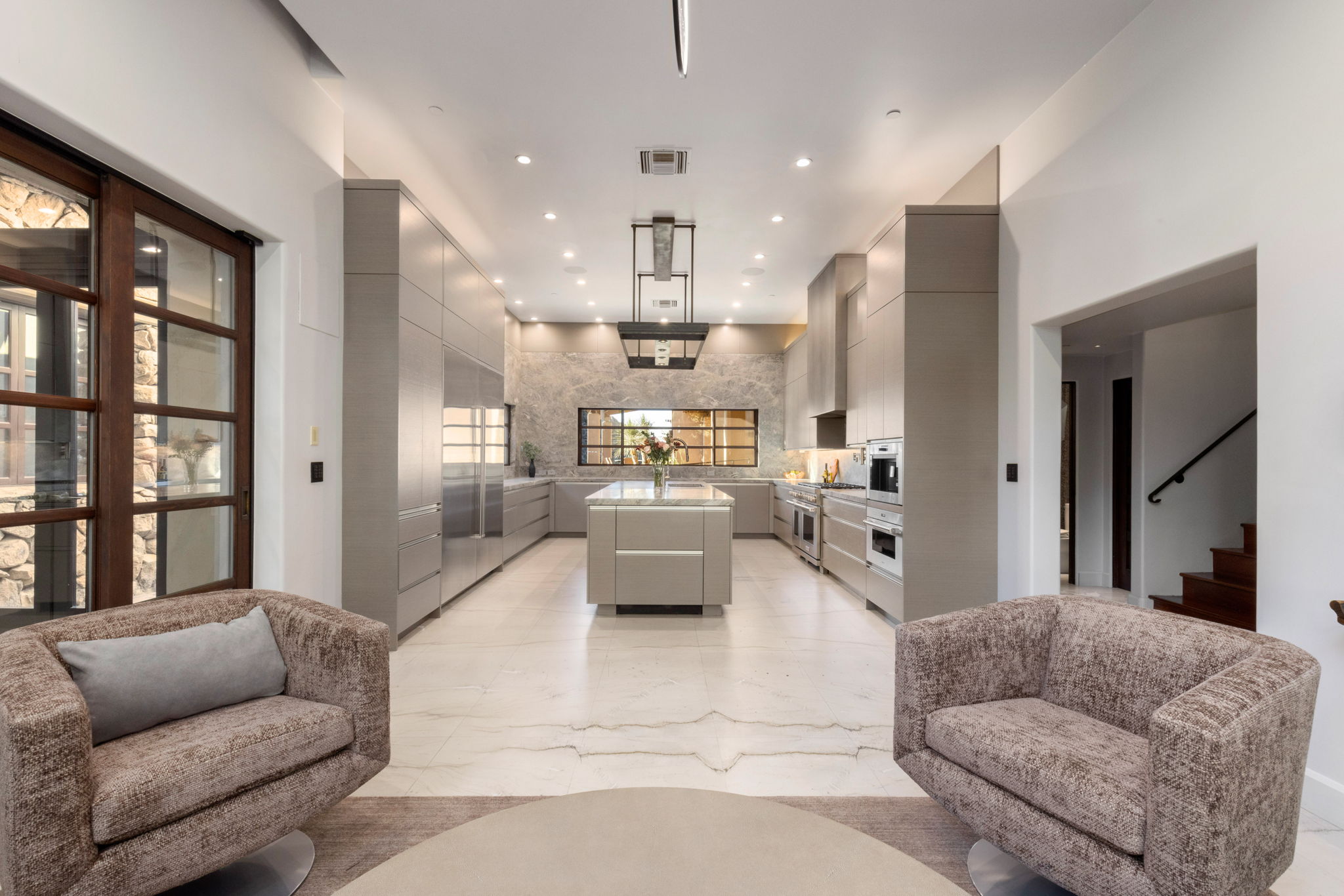 The kitchen, with its monumental stone island and suspended steel hood